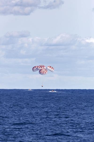 Crew Dragon under parachutes approaching splashdown in the Atlantic