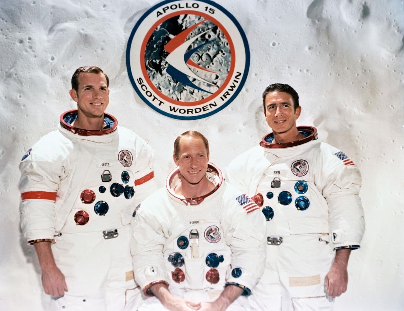 Posádka Apolla 15 (Scott, Worden, Irwin) na pozadí znaku mise (NASA).