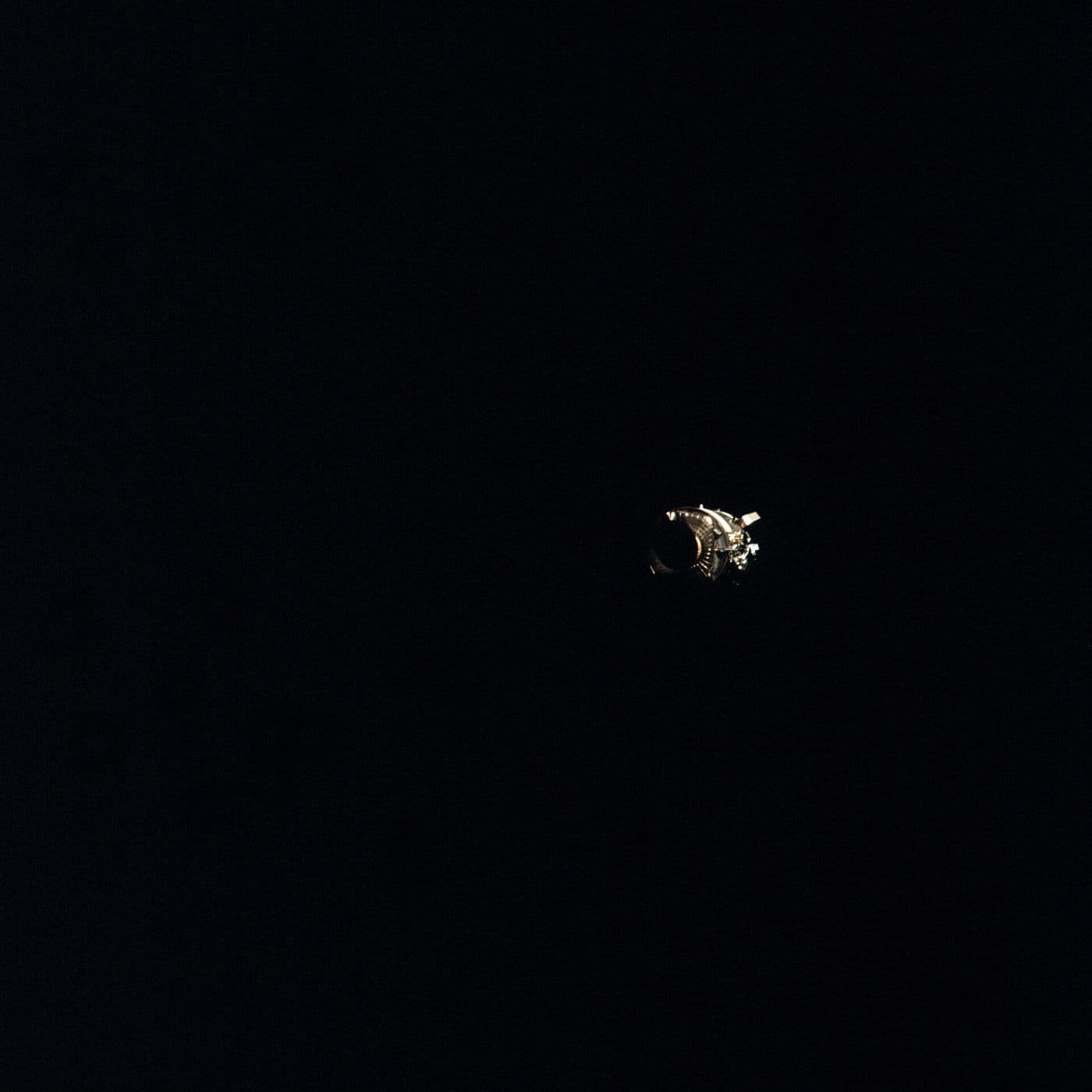 The damaged Apollo 13 service module photographed after separation, showing the panel blown off by the oxygen tank explosion (NASA AS13-59-8500).