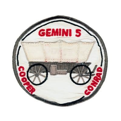 Oficiální znak mise Gemini 5 — starý povoz symbolizující dlouhou cestu k Měsíci.