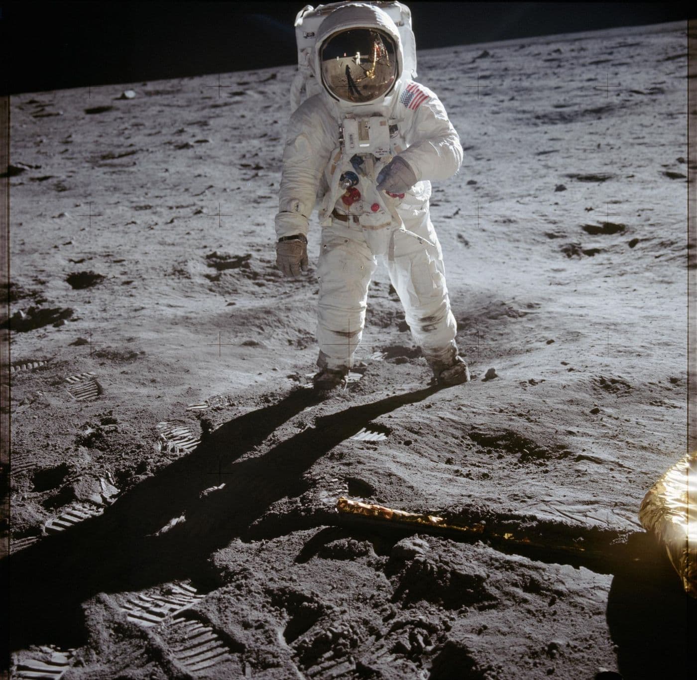 Buzz Aldrin, with Armstrong and the lunar module reflected in his visor (AS11-40-5903).